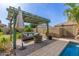 Relaxing outdoor patio with pergola, comfortable seating, and a stone fire pit near the pool at 1036 W Siebold Tree Ave, Queen Creek, AZ 85140