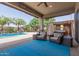 Spacious covered patio area with seating, view of the pool, spa, and beautifully landscaped backyard at 1036 W Siebold Tree Ave, Queen Creek, AZ 85140
