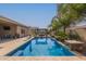 Sparkling pool with stone accents and lush landscaping creates a serene backyard oasis with a covered seating area at 1036 W Siebold Tree Ave, Queen Creek, AZ 85140