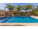 Beautiful backyard pool surrounded by lush palm trees and meticulous hardscaping creates a private retreat at 1036 W Siebold Tree Ave, Queen Creek, AZ 85140