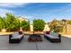 Backyard patio seating area with a fire pit and lush landscaping offers a peaceful outdoor retreat at 11737 N 143Rd Dr, Surprise, AZ 85379