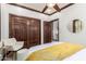 A bedroom with stylish closet, wood trim, ceiling fan, and plenty of natural light at 11737 N 143Rd Dr, Surprise, AZ 85379