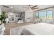 Bright and airy bedroom features a ceiling fan, cozy seating, and large windows for natural light at 11737 N 143Rd Dr, Surprise, AZ 85379