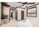 Spacious bedroom with wood trim, ceiling fan, and multiple entryways to other parts of the home at 11737 N 143Rd Dr, Surprise, AZ 85379