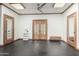 Spacious bonus room with sleek black flooring, modern ceiling fan, and tasteful wooden door and window trim at 11737 N 143Rd Dr, Surprise, AZ 85379