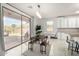 Bright dining area with white cabinets, breakfast bar, and sliding glass door to patio at 11737 N 143Rd Dr, Surprise, AZ 85379