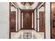 Elegant foyer with a decorative tile floor, a chandelier, and a wooden front door at 11737 N 143Rd Dr, Surprise, AZ 85379
