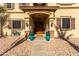 Beautiful home entrance with stone accents, custom door, and potted plants at 11737 N 143Rd Dr, Surprise, AZ 85379