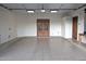 Finished garage featuring epoxy flooring, neutral walls and striking doors to the home interior at 11737 N 143Rd Dr, Surprise, AZ 85379