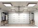 Spacious garage featuring a white door, overhead lighting, and durable epoxy flooring at 11737 N 143Rd Dr, Surprise, AZ 85379