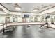 Bright home gym with rubber flooring, mirrored walls, ceiling fans, and exercise equipment at 11737 N 143Rd Dr, Surprise, AZ 85379
