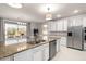 Modern kitchen with stainless steel appliances, granite countertops, and an open view to the backyard patio at 11737 N 143Rd Dr, Surprise, AZ 85379