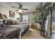 Comfortable bedroom featuring a ceiling fan, wood floors, and an oversized potted houseplant at 1191 E Avenida Fresca St, Casa Grande, AZ 85122
