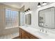Modern bathroom features a double sink vanity, beautiful tile, and glass block for natural light at 12217 W Edgemont Ave, Avondale, AZ 85392
