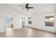 Bright bedroom boasts a ceiling fan, wood-look floors, and access to an ensuite bathroom and closet at 12217 W Edgemont Ave, Avondale, AZ 85392