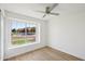 Bright bedroom with a ceiling fan and a view of the street through the large window at 12217 W Edgemont Ave, Avondale, AZ 85392