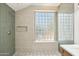 This bathroom features a standing shower with stylish tile, a rain shower head, and niche at 12217 W Edgemont Ave, Avondale, AZ 85392