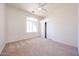 Bedroom with neutral carpet, ceiling fan, closet with sliding doors, and large window at 12721 W Georgia Ave, Litchfield Park, AZ 85340