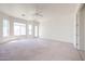 Large living room filled with natural light from many windows, with door to backyard at 12721 W Georgia Ave, Litchfield Park, AZ 85340