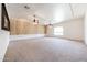 Spacious living room featuring carpeted floors, ceiling fans, and light wood accent wall at 12721 W Georgia Ave, Litchfield Park, AZ 85340