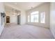 Spacious living room featuring plush carpeting, arched windows, and plenty of natural light at 12721 W Georgia Ave, Litchfield Park, AZ 85340