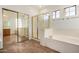 Well-lit bathroom featuring a bathtub, standing shower and a large mirror at 13599 W Monte Vista Rd, Goodyear, AZ 85395