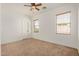 Bedroom featuring carpet flooring, neutral paint, ceiling fan, and large windows at 13599 W Monte Vista Rd, Goodyear, AZ 85395