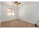 Neutral-toned bedroom featuring carpet floors, a ceiling fan, and a window with blinds at 13599 W Monte Vista Rd, Goodyear, AZ 85395