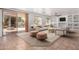Airy living room with large sliding glass door to patio, ceiling fan and built-in shelves surrounding a TV at 13599 W Monte Vista Rd, Goodyear, AZ 85395