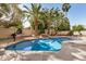 Beautiful pool surrounded by palm trees, rock features, and a basketball hoop at 13599 W Monte Vista Rd, Goodyear, AZ 85395