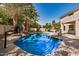Inviting pool area with lush landscaping and a rock feature for a tropical oasis at 13599 W Monte Vista Rd, Goodyear, AZ 85395