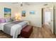 Well-lit bedroom with bed, side table, art, and ensuite bathroom doorway at 13807 N Garden Court Dr, Sun City, AZ 85351