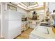 Cozy kitchen features white cabinetry, appliances, and a unique ceiling light fixture at 13807 N Garden Court Dr, Sun City, AZ 85351