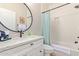 Bathroom featuring modern vanity, large round mirror, and tiled tub shower with linen closet at 139 E Gail Dr, Gilbert, AZ 85296
