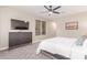 Bedroom features a large bed, ceiling fan, and modern dresser with mounted tv at 139 E Gail Dr, Gilbert, AZ 85296