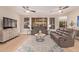 Living room showcasing plush leather seating, decorative rug, and a large flat screen television at 139 E Gail Dr, Gilbert, AZ 85296