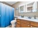 Bathroom with modern vanity, framed mirrors, and a blue shower curtain at 15740 N 91St Dr, Peoria, AZ 85382