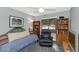 Cozy bedroom with a daybed, bookshelves, ceiling fan, and comfortable chair at 15740 N 91St Dr, Peoria, AZ 85382