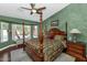 Stunning main bedroom with four-poster bed, decorative green walls, and views to the pool at 15740 N 91St Dr, Peoria, AZ 85382