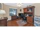 Functional home office featuring a desk, shelves, hardwood floors, and neutral walls at 15740 N 91St Dr, Peoria, AZ 85382
