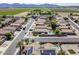 Overview of a residential community showcasing homes with pools and solar panels near farmland at 16186 W Port Royale Ln, Surprise, AZ 85379