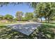 Community basketball court and playground surrounded by mature trees, creating a recreational area at 16186 W Port Royale Ln, Surprise, AZ 85379