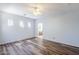 Spacious bedroom featuring wood-look floors, light walls, ceiling fan, and an ensuite bathroom, creating a relaxing retreat at 16186 W Port Royale Ln, Surprise, AZ 85379