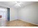 A spacious bedroom with tile flooring, ceiling fan, and neutral walls at 16186 W Port Royale Ln, Surprise, AZ 85379