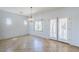 Dining area with tile flooring, a modern chandelier, and access to the backyard through French doors at 16186 W Port Royale Ln, Surprise, AZ 85379
