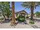 Well-maintained front yard with desert landscaping, mature trees, and charming rock accents at 16186 W Port Royale Ln, Surprise, AZ 85379