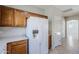White refrigerator next to wooden cabinets with view of adjacent rooms at 16186 W Port Royale Ln, Surprise, AZ 85379