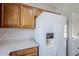 White refrigerator in kitchen next to light wood cabinets and light countertops at 16186 W Port Royale Ln, Surprise, AZ 85379