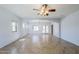 Spacious living room with ceiling fan, recessed lighting, and neutral tile flooring at 16186 W Port Royale Ln, Surprise, AZ 85379