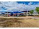 A sprawling playground offers a range of activities for children, shaded from the sun by colorful canopies at 16186 W Port Royale Ln, Surprise, AZ 85379